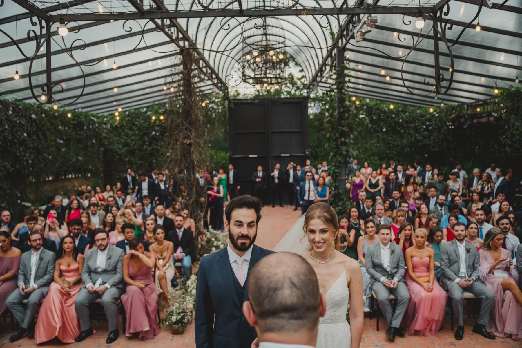 Casamento em espaço com arquitetura de vidro e convidados